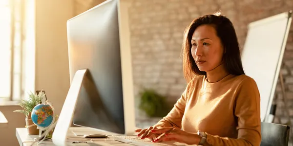 asian-businesswoman-typing-email-desktop-pc-office