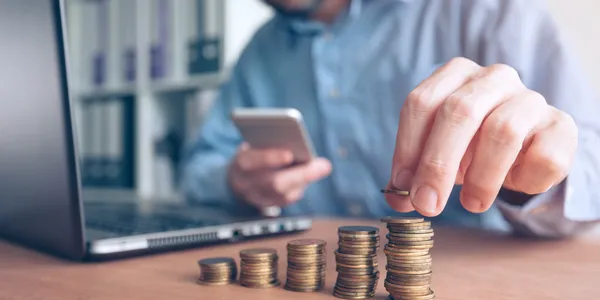 finances-and-budgeting-businessman-stacking-coins-GYFTLC6.jpg