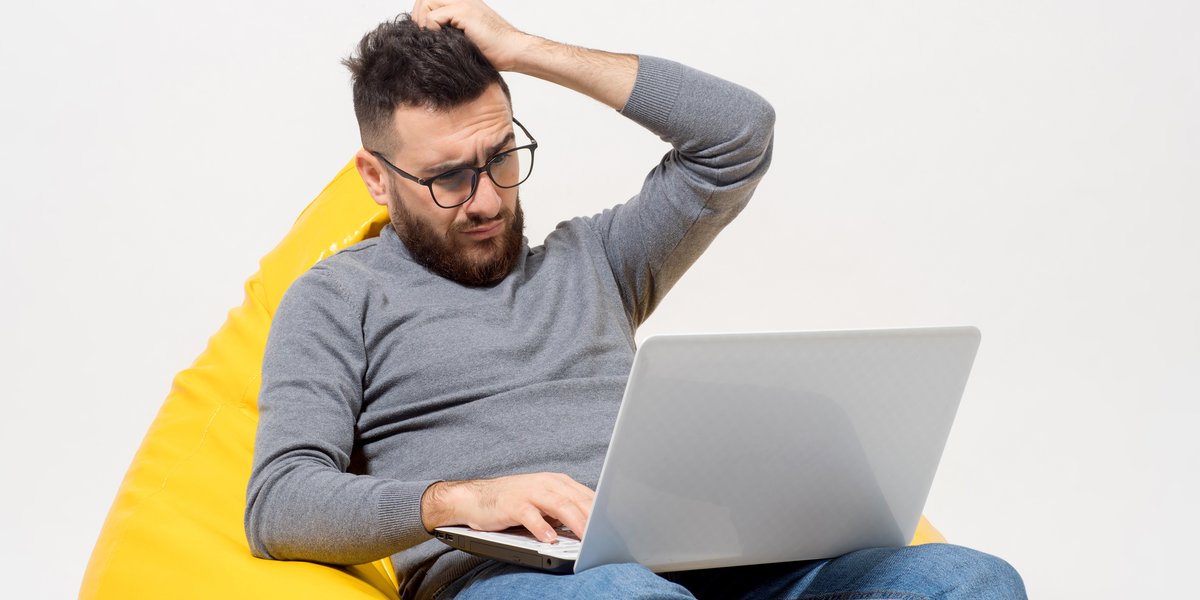guy-frustrated-while-sitting-yellow-pouf-chair