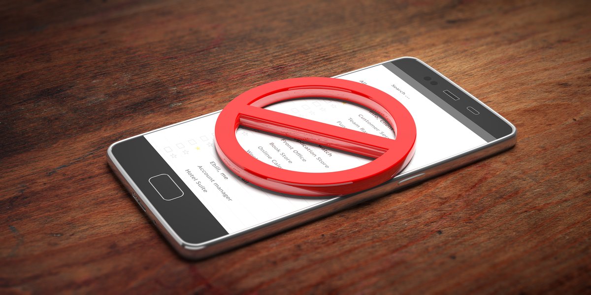 smartphone-crossed-out-sign-wooden-table-3d-illustration