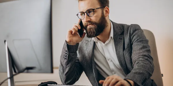 young-business-man-talking-phone-working-computer