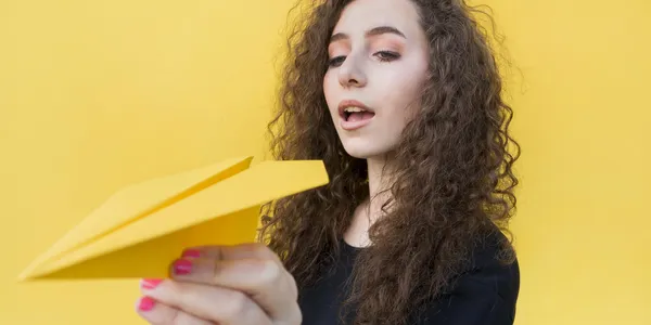 young-girl-holding-paper-plane